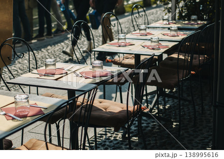 Tables served for lunch in a street cafe on a sunny day. Tables served for lunch in a street cafe on a sunny day. 138995616