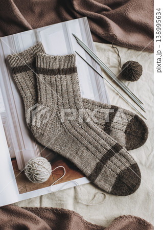 Hand knitted socks with needles and yarn ball. Concept for handmade and hygge slow life. Hand knitted socks with needles and yarn ball. Concept for handmade and hygge slow life. 138995634