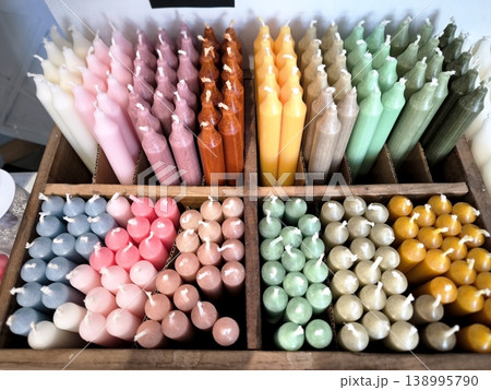 A set of multi-colored wax candles in a wooden box 138995790