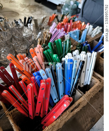 Knives and forks with colorful handles in wicker baskets 138995792