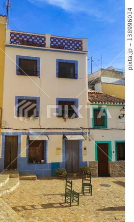 Picturesque white and blue buildings line a sunlit cobbled street in Altea, Spain, inviting travelers to enjoy a relaxing family vacation 138996014