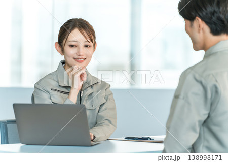会議室でミーティング,打ち合わせをする作業着姿の製造業,工場勤務の男女スタッフ 会議室でミーティング,打ち合わせをする作業着姿の製造業,工場勤務の男女スタッフ 138998171
