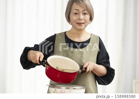 キッチンでベジブロスを作るシニア女性 138998380