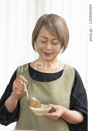 キッチンでベジブロスを作るシニア女性 138998404