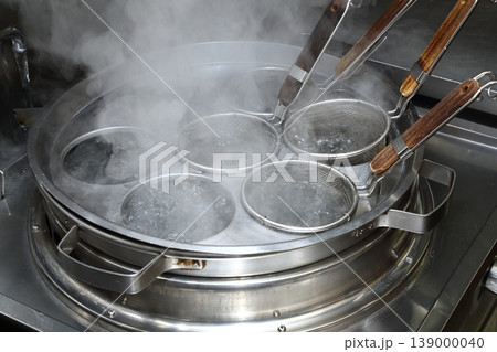 ラーメン店の厨房設備・ゆで麺機で麺を茹でる調理シーン 139000040
