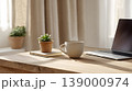 Home office laptop coffee cup wooden table succulent notebook window light minimalist workspace morning routine Modern home office workspace with laptop, coffee cup, succulent, notebook wooden 139000974