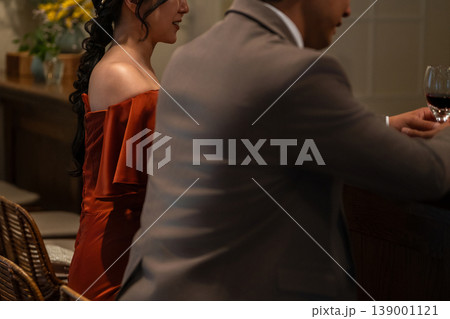 レストラン,バーでワインを飲みながら会話するドレスコード姿のカップル,夫婦の後ろ姿 139001121