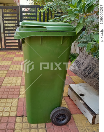 green wheeled dustbin is a heavy-duty outdoor waste management solution 139003297