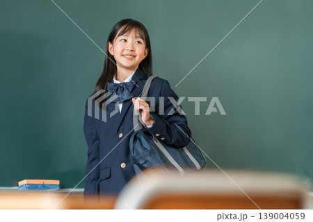 教室の黒板の前に立つスクールバックを持つ制服姿,小学生,中学生,高校生の女子生徒 教室の黒板の前に立つスクールバックを持つ制服姿,小学生,中学生,高校生の女子生徒 139004059
