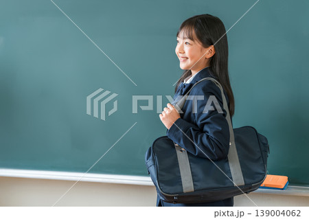 教室の黒板の前に立つスクールバックを持つ制服姿,小学生,中学生,高校生の女子生徒 教室の黒板の前に立つスクールバックを持つ制服姿,小学生,中学生,高校生の女子生徒 139004062