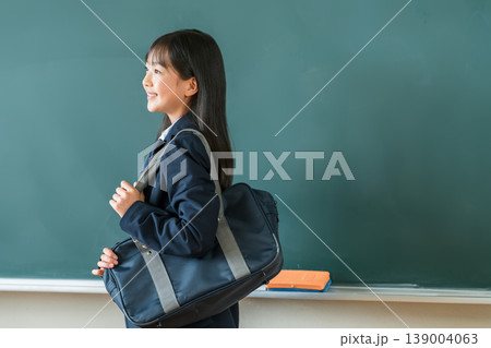 教室の黒板の前に立つスクールバックを持つ制服姿,小学生,中学生,高校生の女子生徒 教室の黒板の前に立つスクールバックを持つ制服姿,小学生,中学生,高校生の女子生徒 139004063