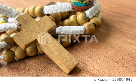 Holy Rosary placed over rosary beads on a warm wooden background representing faith and devotion. Holy Rosary placed over rosary beads on a warm wooden background representing faith and devotion. 139004945