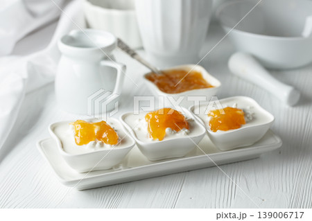 Cottage cheese with cream and mango jam on a white table. Cottage cheese with cream and mango jam on a white table. 139006717
