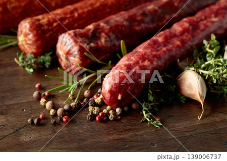 Various dry cured sausages with spices on a old wooden table. Various dry cured sausages with spices on a old wooden table. 139006737