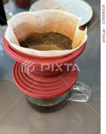 Drip coffee maker with filter brewing fresh coffee grounds in kitchen setting from top view Drip coffee maker with filter brewing fresh coffee grounds in kitchen setting from top view 139006816