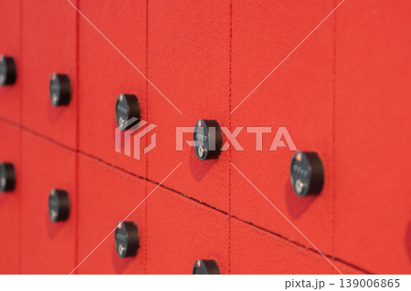 Red textured wall with black combination locks arranged in row modern storage interior Red textured wall with black combination locks arranged in row modern storage interior 139006865