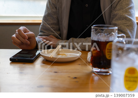 飲み屋でスマホを操作する男性 139007359