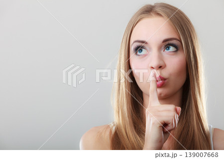 Woman asking for silence finger on lips 139007668