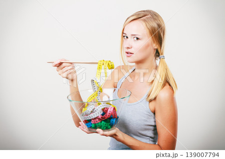Diet. Girl with colorful measuring tapes in bowl Diet. Girl with colorful measuring tapes in bowl 139007794