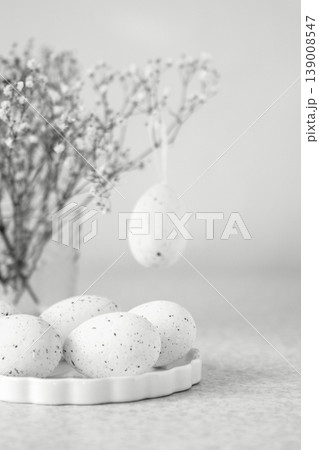 Speckled Easter egg still life with dried gypsophila and hanging ornament on ceramic plate Speckled Easter egg still life with dried gypsophila and hanging ornament on ceramic plate 139008547