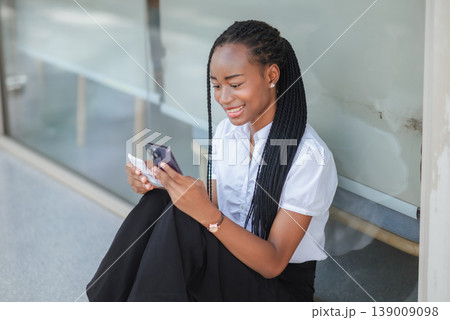 Young African woman sitting and checking receipt with smartphone, concept of budgeting, expense tracking, digital payment review, mobile finance and modern personal money management. Young African woman sitting and checking receipt with smartphone, concept of budgeting, expense tracking, digital payment review, mobile finance and modern personal money management. 139009098