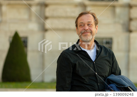 Man 50-55 years old looking aside showing confidence calm control and positive mood outdoors Man 50-55 years old looking aside showing confidence calm control and positive mood outdoors 139009248
