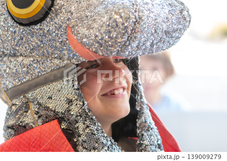 Girl 7 years old in costume with shiny helmet smiling and playing Girl 7 years old in costume with shiny helmet smiling and playing 139009279
