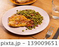 Delicious crispy chicken with peas as a side dish on a plate 139009651