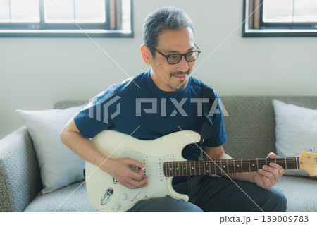 ソファーでギターを弾くシニア男性 139009783