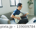 ソファーでギターを弾くシニア男性 139009784