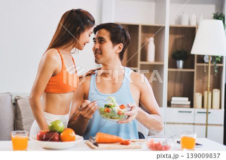 A happy couple prepares fresh vegetables, laughing and enjoying cooking a healthy meal together. A happy couple prepares fresh vegetables, laughing and enjoying cooking a healthy meal together. 139009837