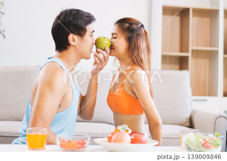A happy couple prepares fresh vegetables, laughing and enjoying cooking a healthy meal together. A happy couple prepares fresh vegetables, laughing and enjoying cooking a healthy meal together. 139009846
