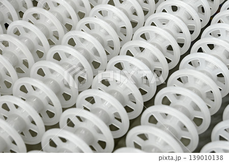 White plastic rollers of industrial conveyor, production, sorting, or transportation line 139010138