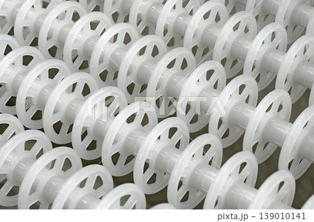 White plastic rollers of industrial conveyor, production, sorting, or transportation line White plastic rollers of industrial conveyor, production, sorting, or transportation line 139010141