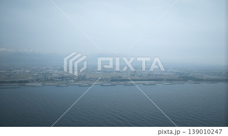 霞のかかった富山県東部下新川海岸周辺の離岸堤や防波堤や防風林などの風景 139010247