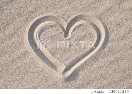 Shape of heart drawn on the sand, close up. Concept of love, passionate feelings, positive emotions, being in love Shape of heart drawn on the sand, close up. Concept of love, passionate feelings, positive emotions, being in love 139011389