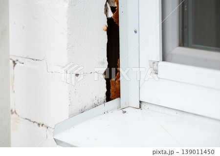 Deterioration of building, crack on the wall near window. Structural foundation errors in building, incorrect building 139011450