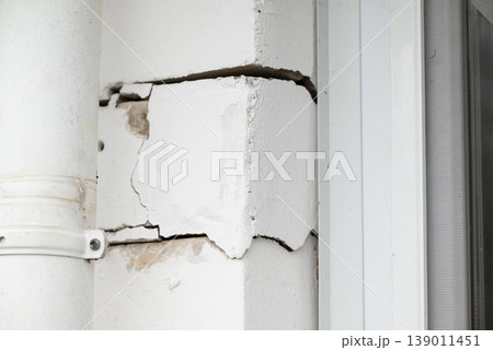 Brick wall of a house with cracks, errors in building. House with many cracks between bricks, problems with foundation of a building Brick wall of a house with cracks, errors in building. House with many cracks between bricks, problems with foundation of a building 139011451