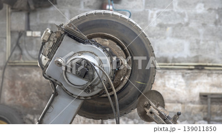 Close-up of an industrial tire changer with an installed truck wheel Close-up of an industrial tire changer with an installed truck wheel 139011850