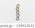 Stack of Metallic Nuts with One Gold Nut 139012632