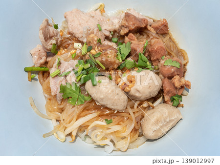 Experience the depth of Sen Lek Haeng - thin rice noodles infused with a rich soy and garlic reduction. This dry-style dish pairs buttery, slow-braised pork with lean pork loin and snappy meatballs 139012997