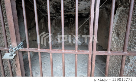 An ancient cave that is said to have been a prison seen through the iron fence 139013775