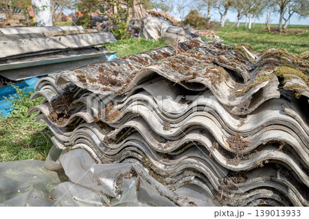Old asbestos roof tiles stacked on a pallet. Old asbestos roof tiles stacked on a pallet. 139013933