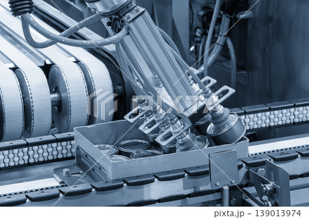 High-technology automated process of packing food cans into container boxes on a conveyor belt. High-technology automated process of packing food cans into container boxes on a conveyor belt. 139013974