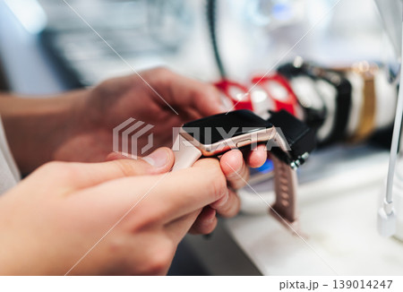 Hands Holding Gold Smartwatch In Electronic Store Hands Holding Gold Smartwatch In Electronic Store 139014247