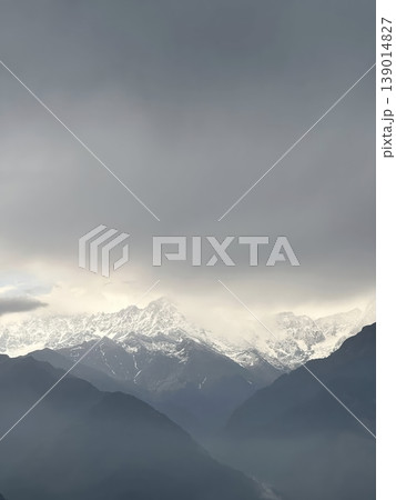 Dramatic Landscape of Snow-Capped Mountain Peaks under a Moody Overcast Sky 139014827