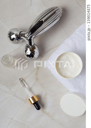 Skincare serum dropper bottle with facial roller massager on marble background, beauty treatment and cosmetic routine concept Skincare serum dropper bottle with facial roller massager on marble background, beauty treatment and cosmetic routine concept 139014875