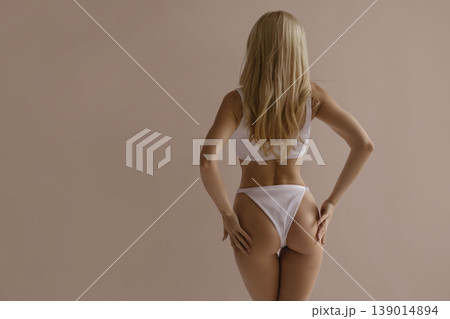 Attractive female body from back with toned hips and smooth skin in white lingerie, beauty and body care concept Attractive female body from back with toned hips and smooth skin in white lingerie, beauty and body care concept 139014894