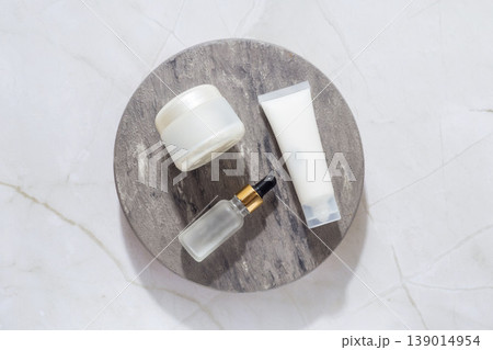 Minimal skincare set with cream jar, cosmetic tube and serum dropper on marble tray, beauty routine concept Minimal skincare set with cream jar, cosmetic tube and serum dropper on marble tray, beauty routine concept 139014954