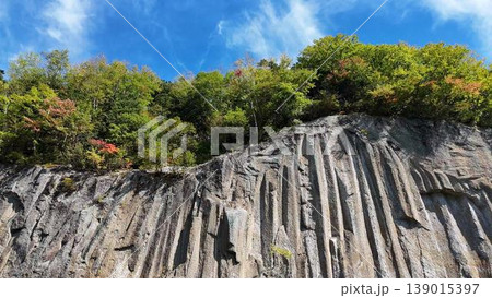 【空撮】見上げる柱状節理の圧倒的スケール！層雲峡にそそり立つ巨大な岩壁 139015397